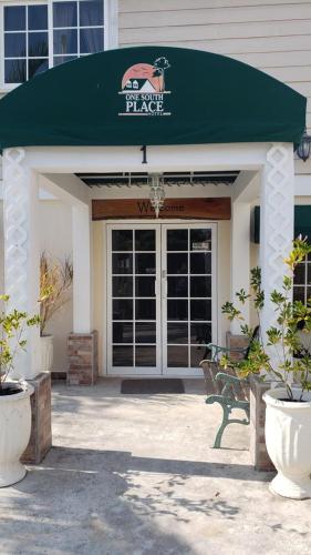 a building with a green awning in front of a door at One South Place Hotel in Belize City