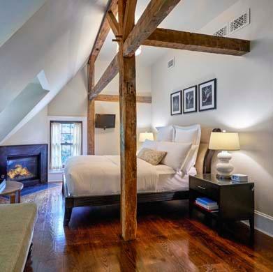 ein großes Schlafzimmer mit einem Bett und einem Kamin in der Unterkunft Bedford Post Inn in Bedford