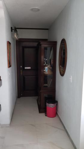 a hallway with a door and a red trash can at One South Place Hotel in Belize City