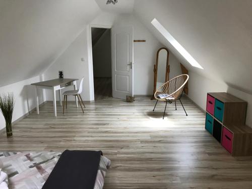 a bedroom with a bed and a table and chairs at BlackBerry Cottage - Maison de vacances - with WIFI in Lessay