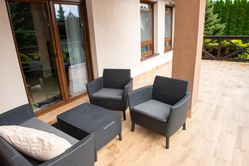 a patio with three chairs and a table at Charming place - Kraków Gdów Jacuzzi in Gdów