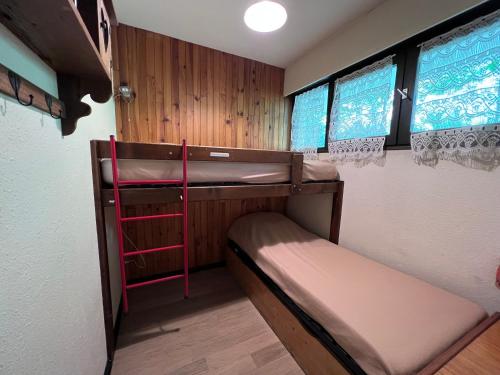 una habitación con dos literas y dos ventanas en Crystal 14 - Appartement centre village, en La Clusaz