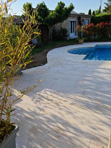 a concrete walkway next to a swimming pool at Petit gite de Provence in Mazan
