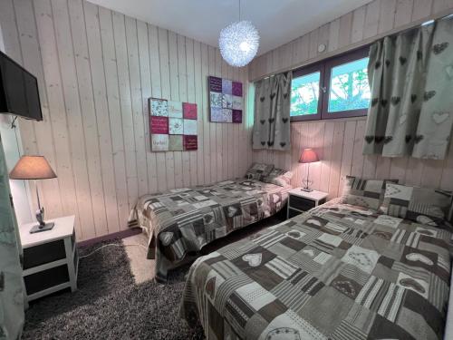 1 Schlafzimmer mit 2 Betten und 2 Lampen sowie einem TV in der Unterkunft Crystal 15 - 2 pieces centre in La Clusaz