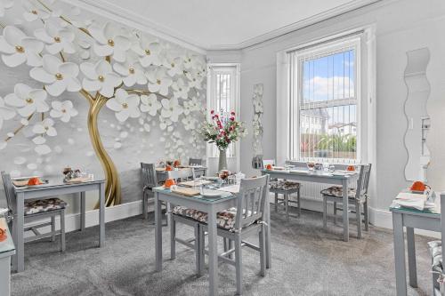 a dining room with a table and a flower mural at St Edmunds Guest House in Paignton