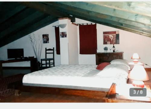 a bedroom with a large white bed and a desk at La fontanella in Loceri