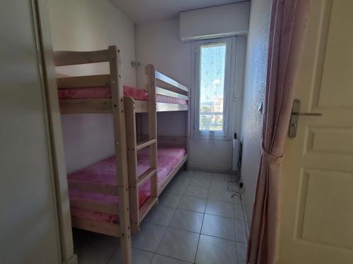 une chambre avec deux lits superposés et une fenêtre dans l'établissement Port FREJUS Rives Latines Studio Cabine 30 m2 4 Pe, à Fréjus
