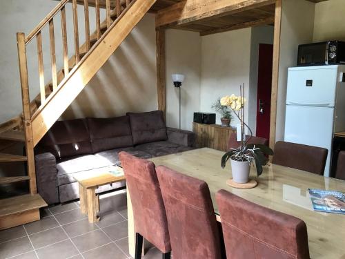 a living room with a table and a couch at Nordique Symbiose in Chapelle-des-Bois