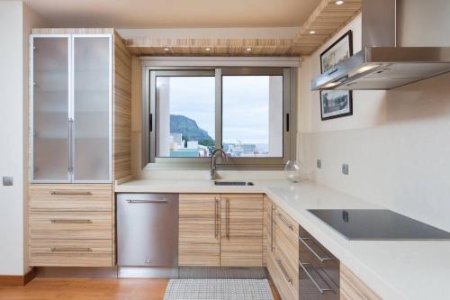 una cocina con fregadero y ventana en Marble Apartments, en San Andrés