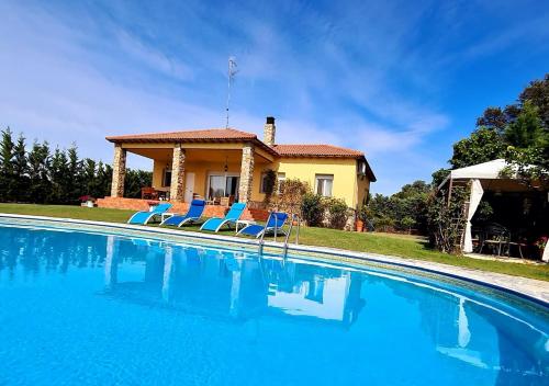 a villa with a swimming pool in front of a house at Casa Prana in Ávila