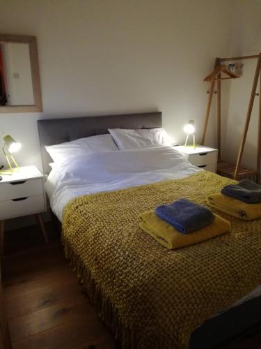 a bedroom with a bed with two towels on it at The Little Flat on the Corner in Cromer