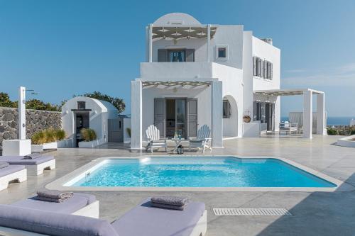 a villa with a swimming pool in front of a house at Hemera Holiday Home villa on Santorini in Akrotiri
