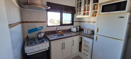 una pequeña cocina con nevera blanca y fregadero en Lindas Vistas Apartment, en Piriápolis