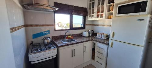 una piccola cucina con frigorifero bianco e lavandino di Lindas Vistas Apartment a Piriápolis