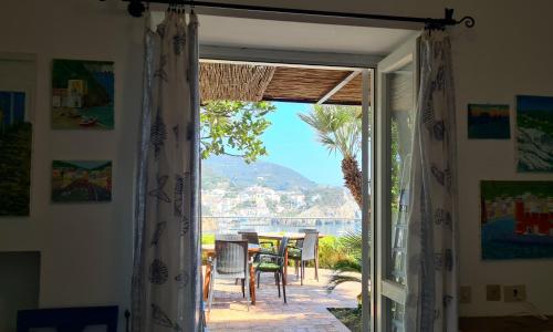 una puerta que conduce a un patio con mesa y sillas en La Limonaia a mare, en Ponza