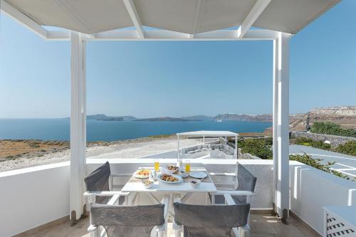 a table on a balcony with a view of the ocean at Hemera Holiday Home villa on Santorini in Akrotiri