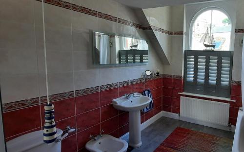 a bathroom with a sink and a mirror at Newly Refurbished 2nd Floor Apartment Lil Nauti in Fowey