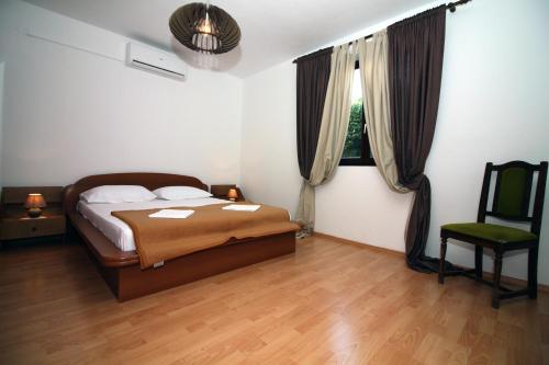 ein Schlafzimmer mit einem Bett und einem Stuhl und einem Fenster in der Unterkunft Kate's Home Tisno in Tisno