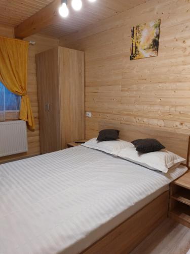 Cette chambre en bois comprend un grand lit. dans l'établissement Cabana Rustica Georgeta, à Zărneşti