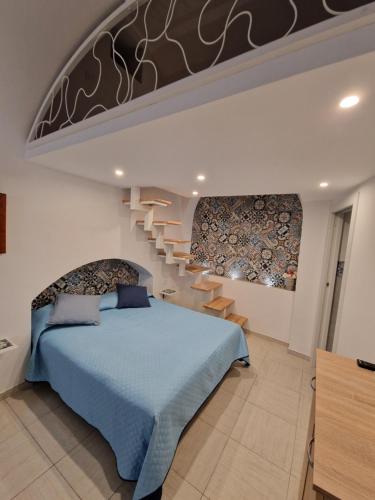 una camera con un letto blu e una scala di Casa Fiore Centro Storico Gallipoli a Gallipoli