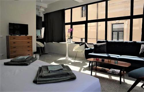 Central urban studio A في أثينا: غرفة معيشة مع أريكة سوداء وطاولة