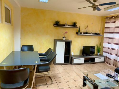 een wachtkamer met een tafel en stoelen en een tv bij Apartments Rhona I und II Neunkirchen City in Neunkirchen