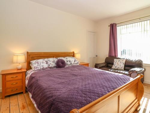 Un dormitorio con una cama y un sofá y una ventana. en Blue Skies Cottage, en Arbroath