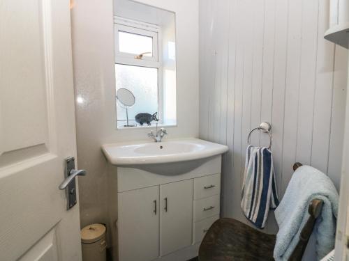 un baño con lavabo y espejo en Blue Skies Cottage, en Arbroath