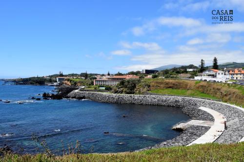 a stone wall next to a body of water at Casa Dos Reis - Boutique Hostel in Angra do Heroísmo