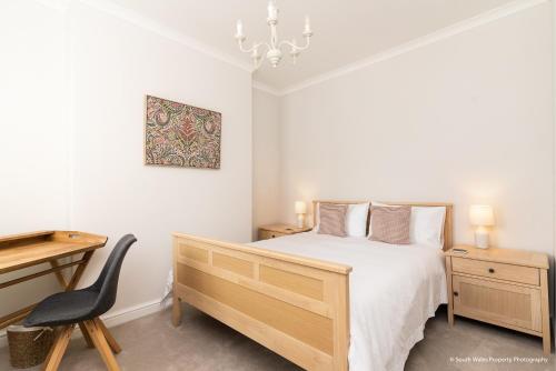 a bedroom with a bed and a desk and a chair at 6 Woodville in The Mumbles