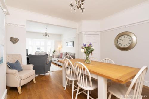 a dining room and living room with a table and chairs at 6 Woodville in The Mumbles
