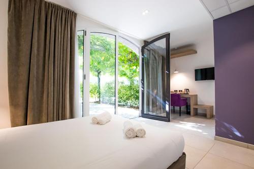 - une chambre avec un grand lit et 2 serviettes dans l'établissement Hôtel du cros d'Auzon, à Saint-Maurice-dʼArdèche