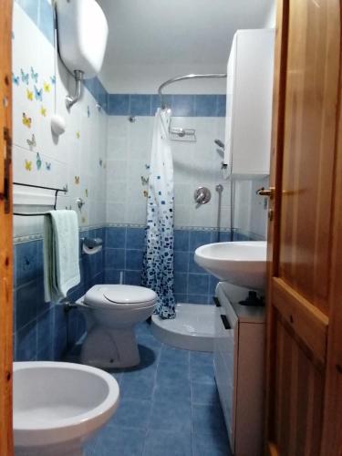 a blue and white bathroom with a toilet and a sink at Casa sul mare in Procida