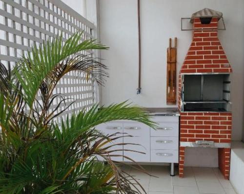 a kitchen with a stove and a brick oven at Casa da Lua Buzios in Búzios