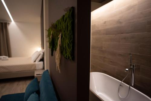 een badkamer met een bad en een slaapkamer met een bed bij House Room Civico 56 in Crotone