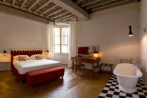 a bedroom with a bed and a tub and a sink at Casa G. Firenze in Florence