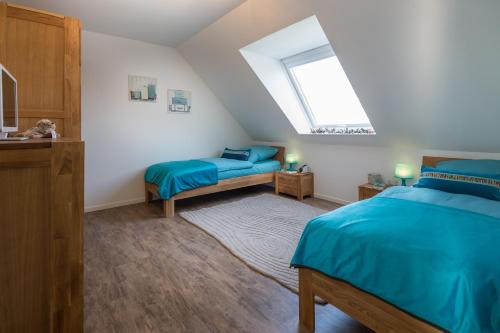 a attic bedroom with two beds and a window at Louise am Meer in Norderney