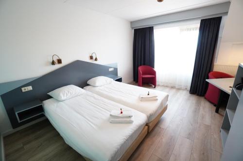 Een bed of bedden in een kamer bij Hotel Brasserie Den Burg