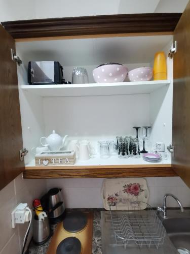 a kitchen cabinet filled with dishes and a sink at HAMBOULA in Polis Chrysochous