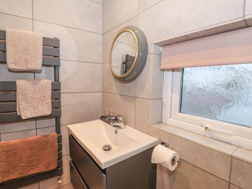 un bagno con un lavandino, uno specchio e una finestra di The Lookout a Millom