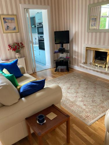a living room with a couch and a fireplace at Rose Cottage in Prestwick