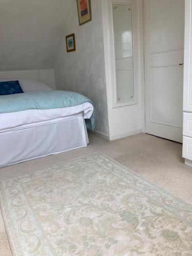 a bedroom with a bed and a rug on the floor at Rose Cottage in Prestwick