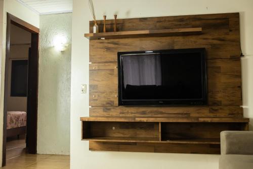 a flat screen tv on a wooden wall at TOLEDO'S HOUSE in São Francisco de Paula