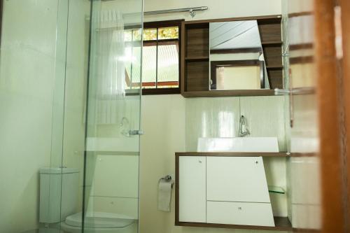 a bathroom with a toilet and a sink and a mirror at TOLEDO'S HOUSE in São Francisco de Paula