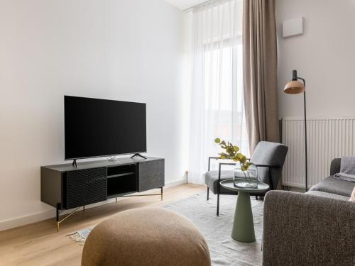 a living room with a flat screen tv on a wall at Limehome Bodenmais Bahnhofstraße in Bodenmais