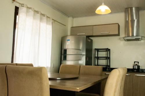 a kitchen with a table and chairs and a refrigerator at TOLEDO'S HOUSE in São Francisco de Paula