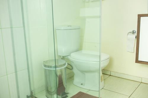 a bathroom with a toilet and a glass shower at TOLEDO'S HOUSE in São Francisco de Paula