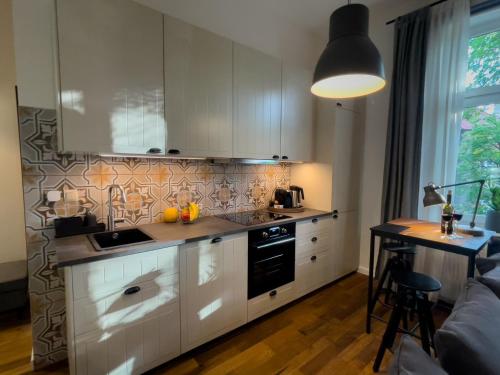 uma cozinha com armários brancos e uma bancada em URBAN APARTMENTS PREMIUM Poniatowskiego 23 No 4 Chorzów Katowice FREE PUBLIC PARKING em Chorzów