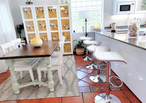 a kitchen with a wooden table and white chairs at Villa Prana in Avila