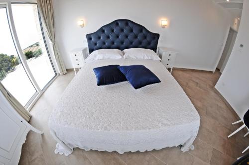 a bedroom with a large bed with a blue headboard at Carrua in Marzamemi